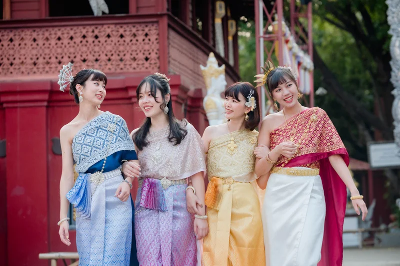 Four women in colorful Thai Sabai dresses at temple — Sabai Thai Dressing