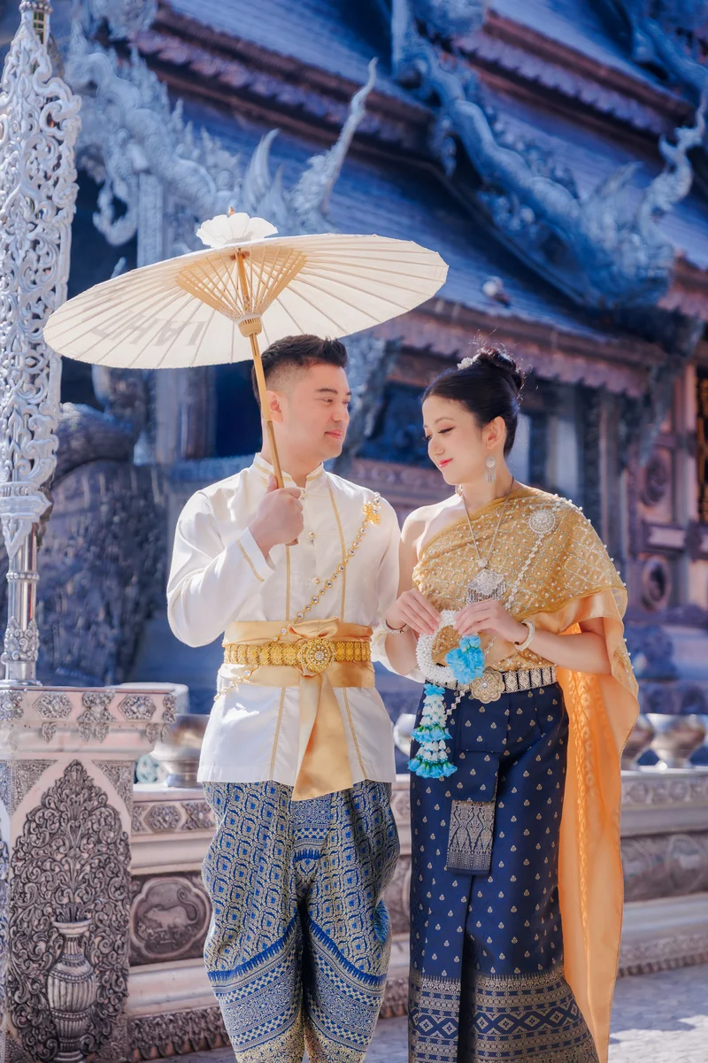 Couple in Thai traditional costumes at temple setting