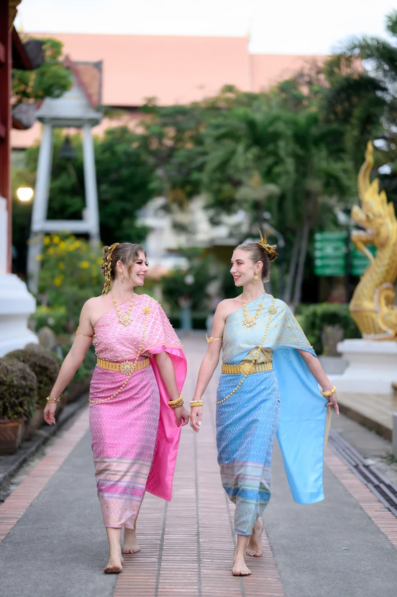 Woman in Thai sabai blue costume at golden pagoda — couples experience
