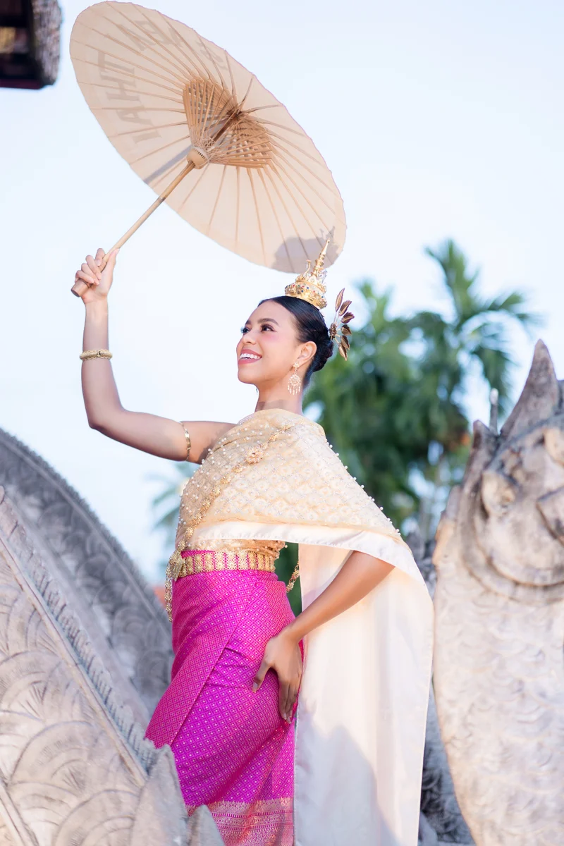 Woman in gold and pink Thai dress with umbrella at temple — Sabai Thai Dressing